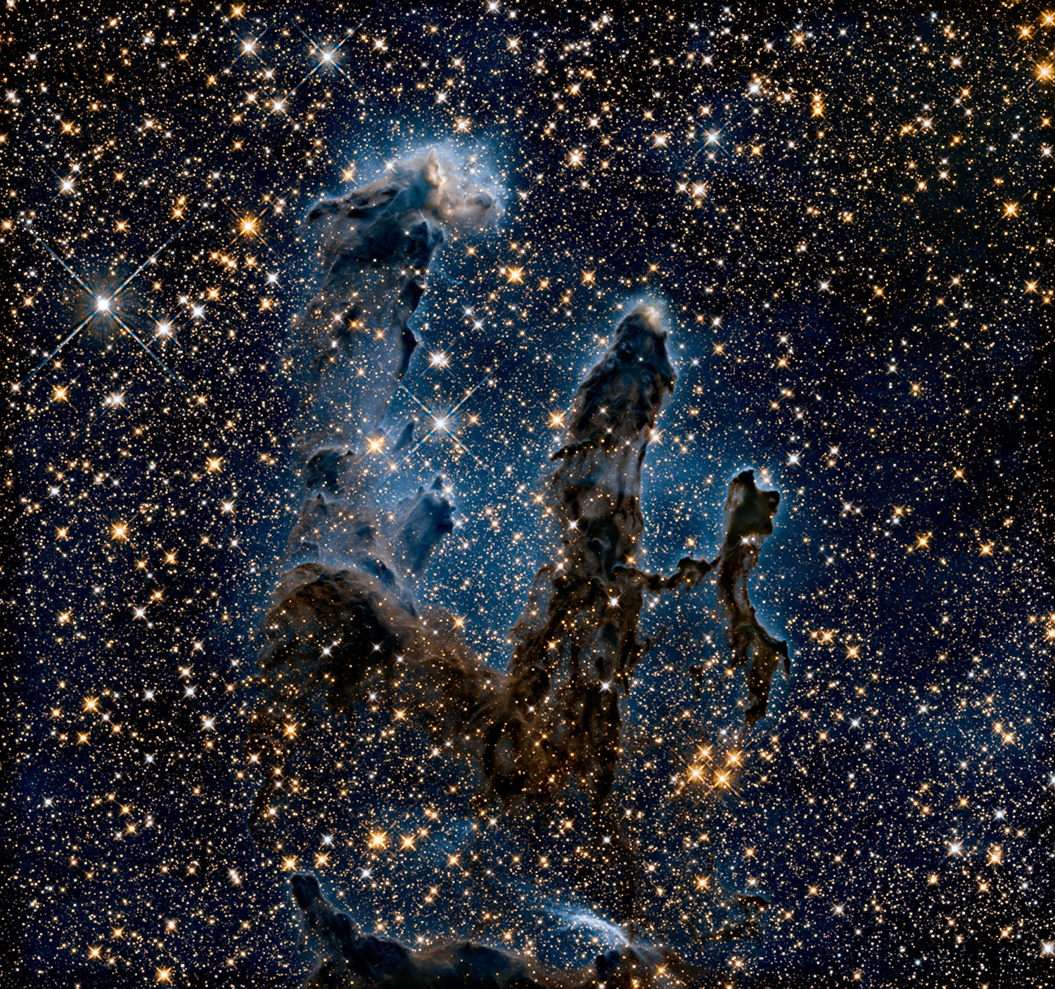 Los Pilares de la Creación se muestran en luz infrarroja, revelando más estrellas ocultas por el gas y el polvo.