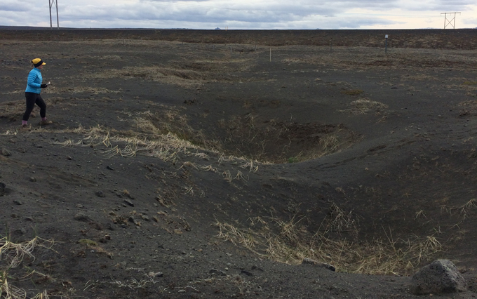 Una persona camina cerca de cráteres de cadenas en Islandia.